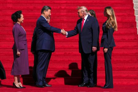 握手する中国の習近平国家主席（中央左）とトランプ米大統領（同右）＝２５日、ワシントン（ＡＰ＝共同）