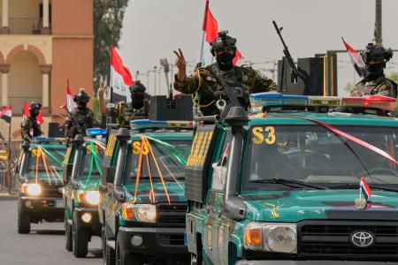 ３０日、イラクの首都バグダッドで、米軍主導の有志連合軍が撤収を完了したことを祝うイラク治安部隊のメンバーら（ＡＰ＝共同）