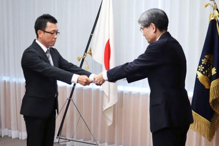 警察庁の楠芳伸長官（右）から上席サイバー捜査分析官に任命される浜石佳孝氏＝１日午後、警察庁
