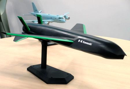 川崎重工業が開発する無人航空機のイメージ模型（手前）＝６日午後、東京都大田区