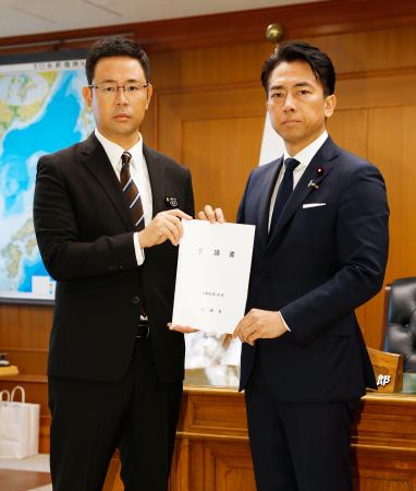 在沖縄米兵の事件を受け、小泉防衛相（右）に要請書を手渡す沖縄県の古謝玄太知事＝７日午前、防衛省