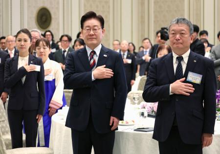 ７日、韓国大統領府での懇談会に出席した李在明大統領（中央）と民団中央本部の金利中団長（右）（聯合＝共同）