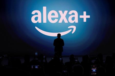 スクリーンに表示された米アマゾン・コムの「アレクサ・プラス」のロゴ=2025年2月、ニューヨーク(ロイター=共同)
