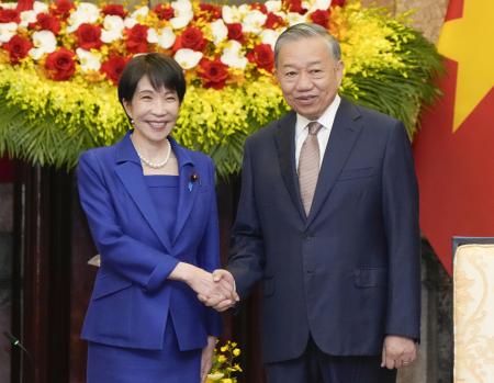 ５月、ベトナムのトー・ラム共産党書記長兼国家主席（右）と握手する高市首相＝ハノイ（共同）