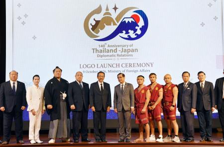日本とタイの修好１４０年記念ロゴの前で関係者らと写真に納まる日本相撲協会の八角理事長（左から４人目）＝９日、バンコク（共同）