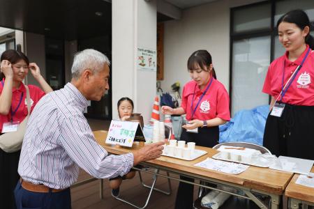 薬膳茶を振る舞う神戸学院大の中田愛香さん（右から２人目）ら＝１１日午後、熊本県八代市