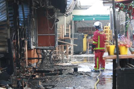 全焼した市場「マルシェ・デ・ザンファン・ルージュ」で消火活動に当たる消防士=12日、パリ(共同)