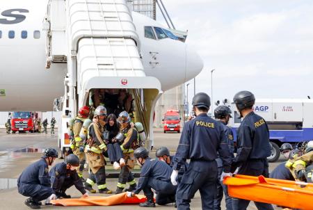 旅客機の事故を想定し、機内から救出された負傷者を運ぶ訓練＝１５日午後、成田空港