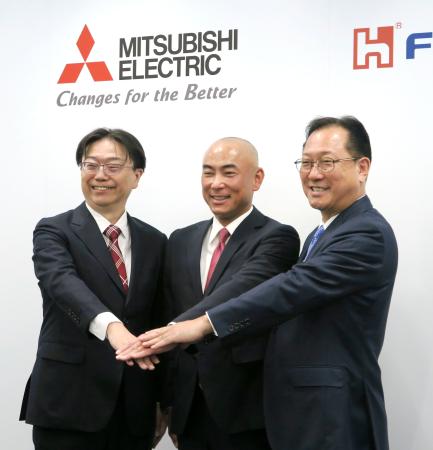 三菱電機との協業に合意し、写真に納まる鴻海精密工業の関潤氏（右）ら＝１９日午後、東京都内