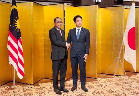 会談前に握手するマレーシアのカレド国防相（左）と小泉防衛相＝１９日午後、東京都内