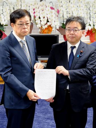上野厚労相(右)に「異常分娩」の用語に関する報告書を手渡す日本産科婦人科学会の関沢明彦副理事長=20日午前、東京都千代田区