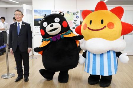 気象庁の野村竜一長官（左）、マスコットキャラクター「はれるん」（右）と写真に納まる「くまモン」＝２０日午後、気象庁