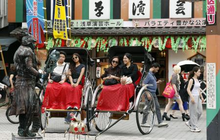 東京・浅草で人力車を楽しむ外国人観光客。周辺では多くの訪日客が行き交っていた＝７月