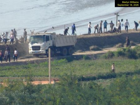 軍事境界線の北朝鮮側で行われている整備作業=9月、韓国・金浦市から撮影(38ノース提供・共同)