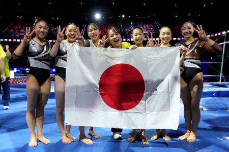 体操世界選手権の女子団体総合で銅メダルを獲得し喜ぶ（左から）岸里奈、西山実沙、杉原愛子、村上茉愛監督、中村遥香、岡村真、山口幸空。ロサンゼルス五輪の切符を手にした＝２１日、オランダ・ロッテルダム（共同）