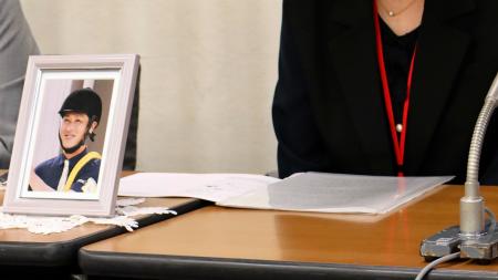 記者会見する厩務員（左の写真）の遺族ら＝２２日午後、厚労省