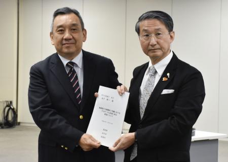 原子力規制庁の金子修一長官（左）に要望書を手渡す鳥取県の平井伸治知事＝２２日午後、東京都港区