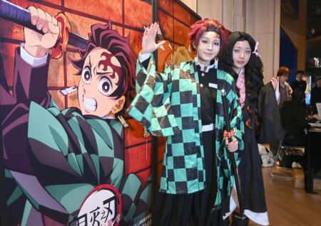 中国上海市の映画館で、劇場版「鬼滅の刃」の上映前に記念撮影するコスプレ姿のファン=2025年11月(共同)